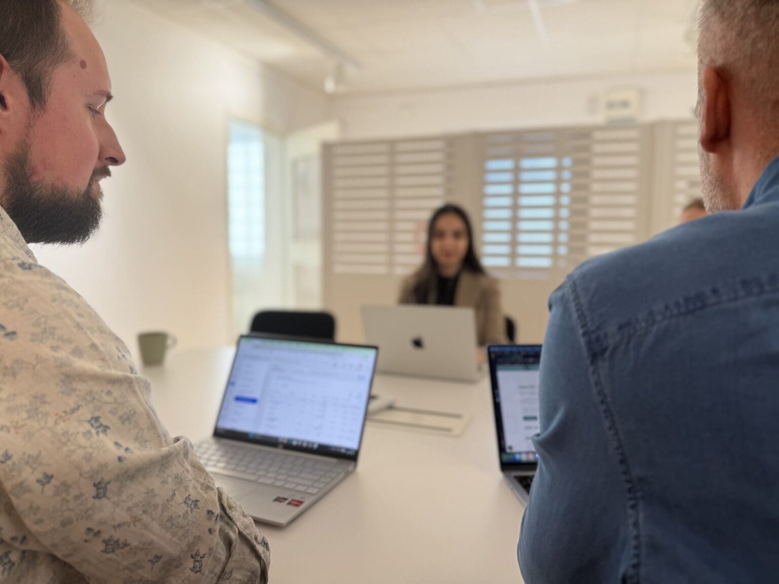 Tre personer i kontorslandskap som tittar på datorer