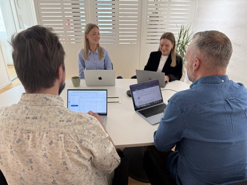 Fyra personer i ett kontorslandskap som har möte