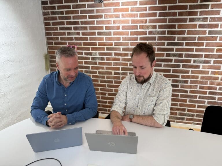 Personer i kontorslandskap som tittar på datorer